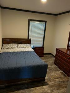 a bedroom with a bed and a dresser and a window at Panther Creek retreat in Clarkesville