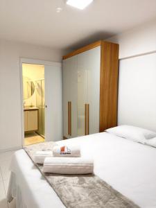 een slaapkamer met een wit bed met handdoeken erop bij Apartamento com Área de Lazer na Cobertura in Cururupe +15 foto's