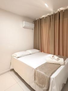 een kleine slaapkamer met een bed met witte lakens bij Apartamento com Área de Lazer na Cobertura in Cururupe