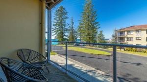 d'un balcon avec deux chaises et une vue sur la rue. dans l'établissement Seaspray Breeze, à Yamba