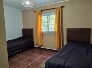 a bedroom with two beds and a window at Cabañas El Ceibo in La Bolsa
