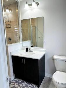 Un baño con lavabo, inodoro y espejo. en Cozy Room in Ayr, en Paris