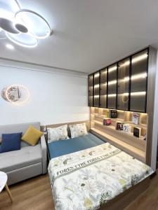 a bedroom with a bed and a couch at Evergreen Bac Giang apartment in Bắc Giang