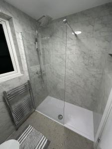 eine Dusche mit Glastür im Badezimmer in der Unterkunft Luxury apartment in Guildford in Guildford