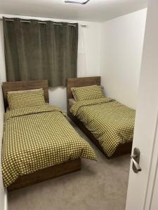 ein Schlafzimmer mit 2 Betten und einer offenen Tür in der Unterkunft Luxury apartment in Guildford in Guildford