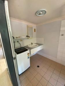 a small bathroom with a sink and a refrigerator at Edmonton Lodge in Edmonton