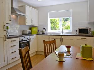 SwimbridgeにあるMoleのキッチン(木製テーブル、椅子、窓付)