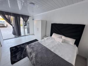 a bedroom with a bed and a large window at No 1 Guest house in Cape Town