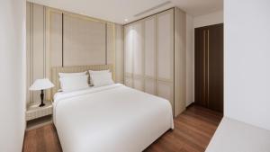 ein Schlafzimmer mit einem großen weißen Bett und einer Lampe in der Unterkunft Aravelle Suites in Hanoi