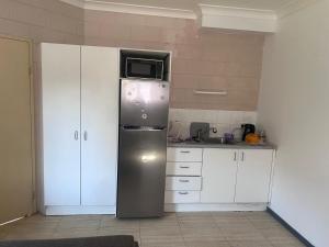 a kitchen with a refrigerator with a microwave on top at Edmonton Lodge in Edmonton