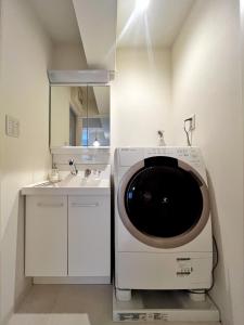 a washing machine in a bathroom with a sink at Roppongi Place in Tokyo