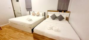 a bedroom with two beds with bowls and towels on them at The time's pool villa in Ban Bung