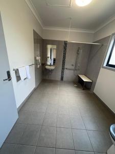 a large bathroom with a shower and a sink at Reef Gardens Motel in Proserpine