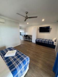 a hotel room with a bed and a flat screen tv at Reef Gardens Motel in Proserpine +4 photos