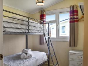 ein Schlafzimmer mit zwei Etagenbetten und einem Fenster in der Unterkunft Harbour Cove - Uk47722 in Saint Merryn