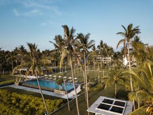 an aerial view of a resort pool with palm trees at Dialoog Banyuwangi in Banyuwangi