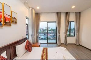 a hotel room with a bed and large windows at Punleu Raksmey Hotel in Siem Reap +26 photos