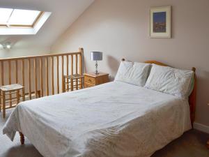 a bedroom with a bed with white sheets and a window at Clougha View - 29531 in Scotforth