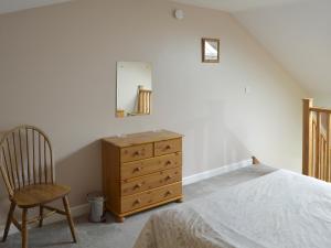 a bedroom with a bed and a dresser and a chair at Clougha View - 29531 in Scotforth