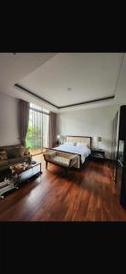 a large bedroom with a bed and a wooden floor at sea l in Jakarta