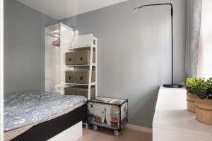 a bedroom with a bed and a shelf with boxes at Central apartement in Kristiansund in Kristiansund