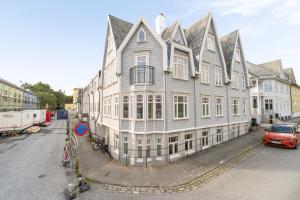 a large white building with a car parked in front of it at Central apartement in Kristiansund in Kristiansund