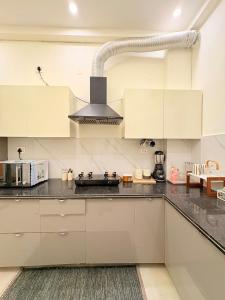 Una cocina con gabinetes blancos y una estufa. en Banana Leaf, en Dehradun