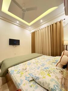 Un dormitorio con una cama y un televisor en el techo. en Banana Leaf, en Dehradun