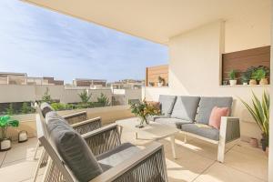 d'un balcon avec des chaises, un canapé et une table. dans l'établissement Lotus Jardinana Paradise - Happy Rentals, à Mijas 32 autres photos