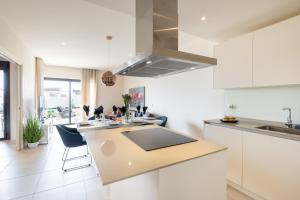 une cuisine avec des armoires blanches et un comptoir dans l'établissement Lotus Jardinana Paradise - Happy Rentals, à Mijas