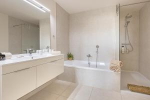 une salle de bain blanche avec une baignoire et un lavabo dans l'établissement Lotus Jardinana Paradise - Happy Rentals, à Mijas