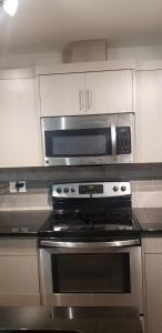 a kitchen with a stove and a microwave at Room to stay in Lethbridge +4 photos