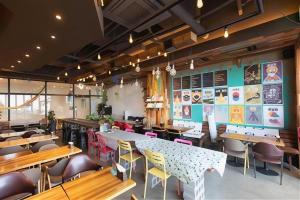 a restaurant with tables and chairs in a room at Ebenezer Hotel in Jeju