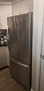 a stainless steel refrigerator in a kitchen at Room to stay in Lethbridge