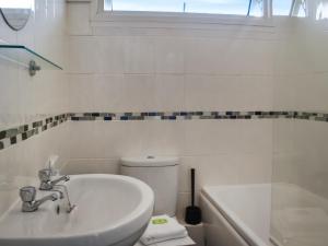 a white bathroom with a sink and a toilet at Old Town Cove - Uk47724 in St Merryn