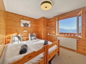 a bedroom with two beds and a window at Mirador Lodge - Crans Montana - Swiss Alps in Randogne