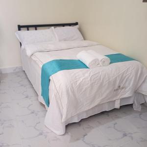 a bed with white sheets and towels on it at DADESA Pl in Kakamega