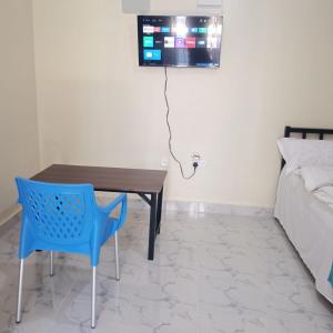 a room with a table and a tv on the wall at DADESA Pl in Kakamega +16 photos