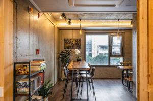 een kamer met een tafel, stoelen en een raam bij Cornerstone Hotel in Seogwipo