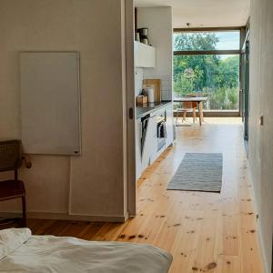 a kitchen with a wooden floor and a kitchen with a table at Natural Wooden House With Panoramic View in Ihlow +14 photos