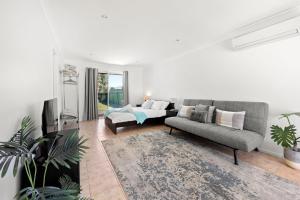 una sala de estar con un sofá y una mesa en Sandy Adventures - Pet Friendly - 1 Min to Beach, en Callala Beach