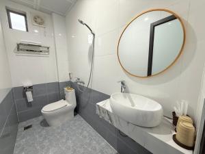 Un baño con lavabo, inodoro y espejo. en Snow Hotel, en Mèo Vạc