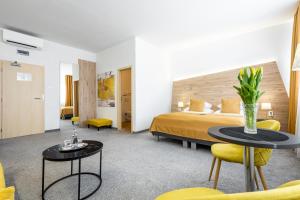 a hotel room with a bed and two tables and chairs at Primma Hotel in Moldava nad Bodvou +107 photos