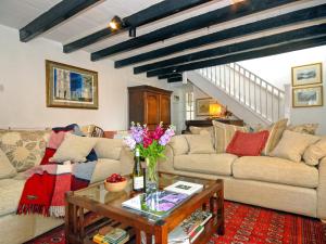 a living room with two couches and a table at Llys Isaf in Saint Nicholas