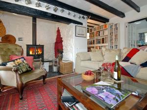 a living room with a couch and a table and a fireplace at Llys Isaf in Saint Nicholas