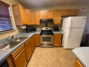 a kitchen with wooden cabinets and a white refrigerator at The Yellow Bench House in Long Beach