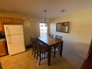a kitchen with a table and chairs and a refrigerator at The Yellow Bench House in Long Beach +12 photos