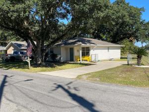 a house with a tree in front of a street at The Yellow Bench House in Long Beach