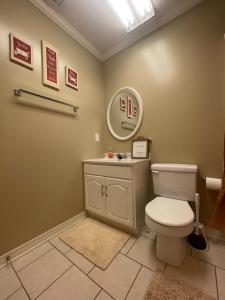a bathroom with a toilet and a mirror at The Yellow Bench House in Long Beach