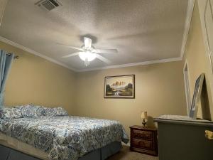 a bedroom with a ceiling fan and a bed at The Yellow Bench House in Long Beach
